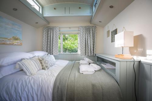 a bedroom with a bed with towels on it at The Showman's Waggon in Hexham