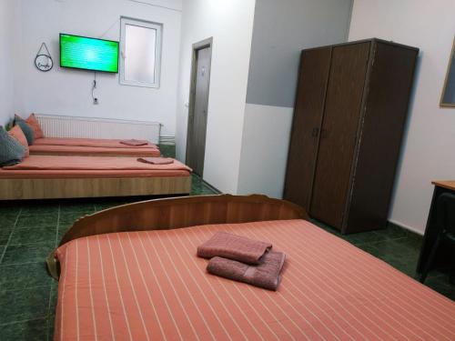 two beds in a room with two towels on a bed at Agape Speranta 96 in Piteşti