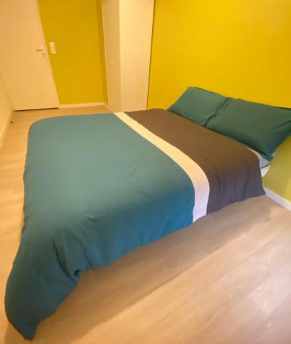 ein großes Bett in einem Zimmer mit gelben Wänden in der Unterkunft Somie in Lille