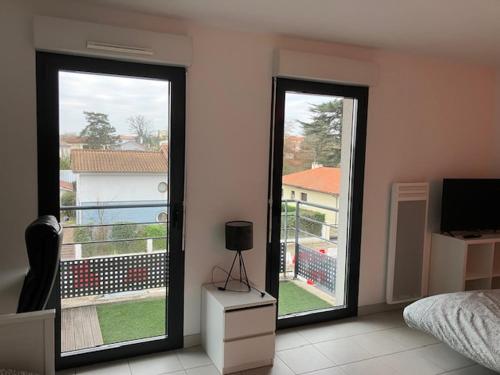 - une chambre avec deux grandes portes coulissantes s'ouvrant sur un balcon dans l'établissement STUDIO BORDEAUX, à Bordeaux
