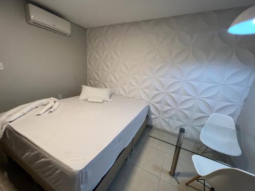 a small room with a bed and a chair at Suítes&Flats MarBello in Maragogi