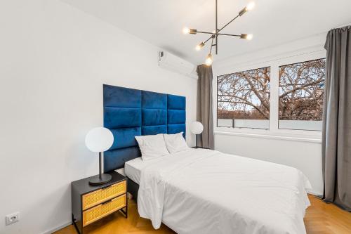 1 dormitorio con 1 cama y cabecero azul en Vienna Chic Residences #Suite 15, en Viena