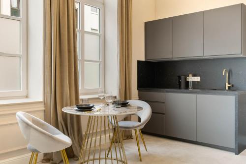 a kitchen with a table and two chairs and a counter at NEW I LUXUS Suite I Kingbed I Center in Augsburg