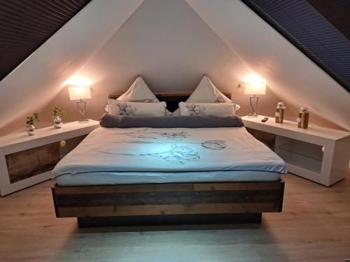 1 dormitorio con 1 cama con 2 lámparas en ambos lados en Ferienhaus Max mit Sauna, en Rehburg-Loccum