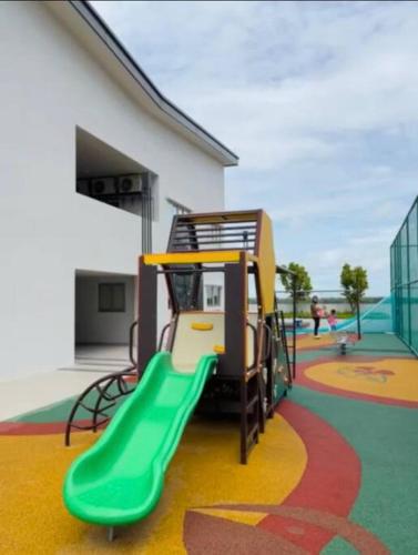 a playground with a green slide in front of a building at RumaMuji Kita KLIA, Putrajaya, Cyberjaya Musliem Only in Sepang