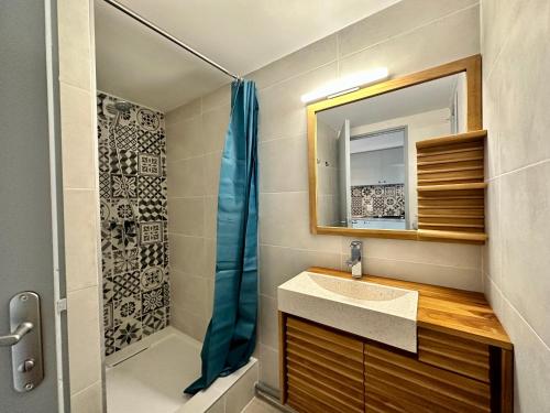 a bathroom with a sink and a shower and a mirror at Appartement Duplex 4pers Climatisé - Location Valadié Camargue in Saintes-Maries-de-la-Mer