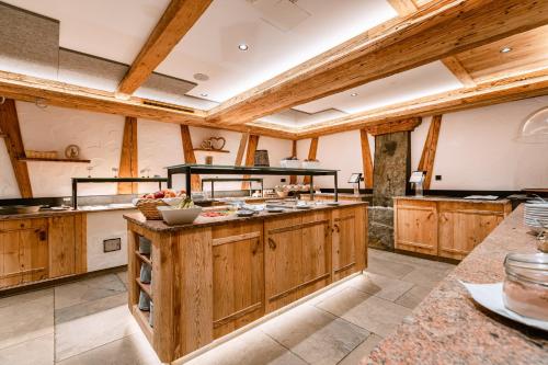 a large kitchen with wooden cabinets and wooden beams at Hotel Restaurant Hexenalm in Söll