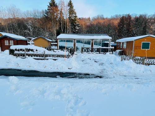 dom ze śniegiem na ziemi obok strumienia w obiekcie Le 77 - chalet nature proche S.Besse w mieście Égliseneuve-dʼEntraigues