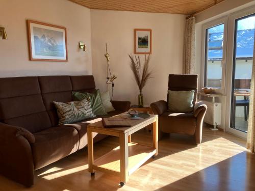 ein Wohnzimmer mit einem Sofa und einem Tisch in der Unterkunft Alpenflair Ferienwohnung 102 Frohnatur in Oberstdorf