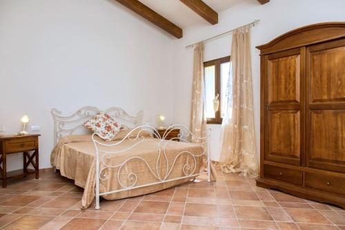 a bedroom with a white bed and a wooden cabinet at Poggio ai Legni in Certaldo