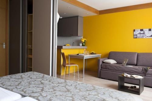 a living room with a couch and a table at Aparthotel Adagio Paris XV in Paris
