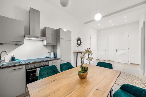 eine Küche mit einem Holztisch und grünen Stühlen in der Unterkunft Vienna Chic Residences #Suite 7 in Wien