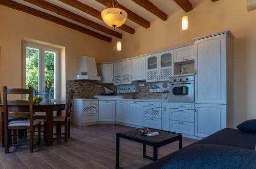 una cocina con armarios blancos y una mesa en una habitación en Villa Ragusa, en Dubrovnik