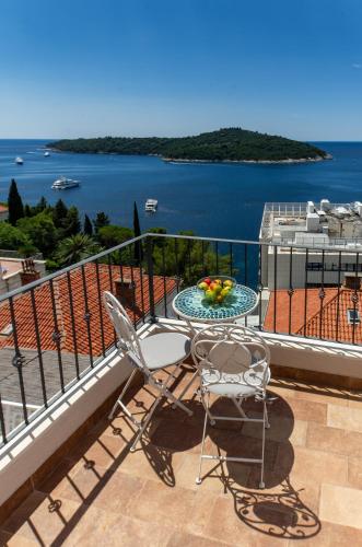a balcony with a table and chairs and a view of the water at Villa Ragusa in Dubrovnik