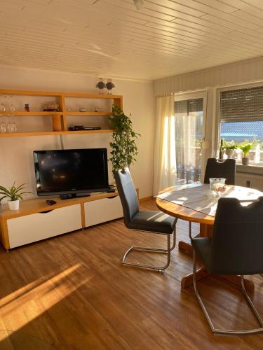 a living room with a table and a tv at Ferienwohnung Euler in Odernheim