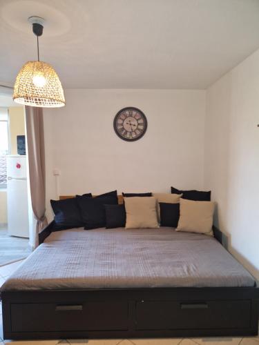 Ce lit se trouve dans un dortoir doté d'une horloge murale. dans l'établissement Les Sablettes,Soleil et douceur I, à La Seyne-sur-Mer