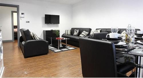a living room with black furniture and a table at Lewis Apartment in the Heart of the Northern Quarter sleeps up to 12 in Manchester
