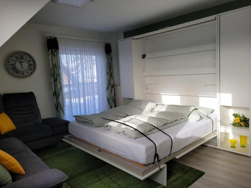 a bedroom with a bed and a chair and a window at Panoramablick Ferienwohnung Luge Winterberg Sauerland in Winterberg