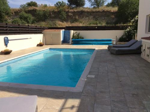 una piscina con agua azul en un patio trasero en Idyllic 3 Bed Villa with Stunning Views, en Pafos