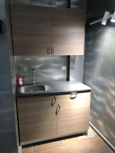 a kitchen with a sink and wooden cabinets at Condo in a Private Resort setting King Maryout Alamriyah Governorate Egypt Comes with an outdoor private infinity swimming pool with a large garden Borg Alarb International Airport is 15 minutes- Families Only in Alexandria
