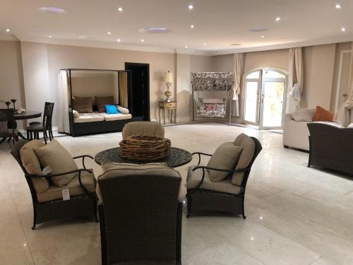 - un salon avec un canapé, une table et des chaises dans l'établissement Condo in a Private Resort setting King Maryout Alamriyah Governorate Egypt Comes with an outdoor private infinity swimming pool with a large garden Borg Alarb International Airport is 15 minutes, à Alexandrie