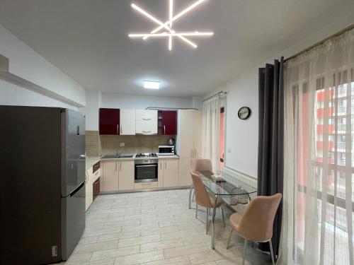 a kitchen with a table and a dining room at River Place Apartment - Iulius Mall in Iaşi