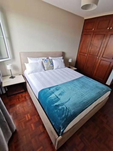 een slaapkamer met een groot bed en een blauwe deken bij Alegria A in Funchal
