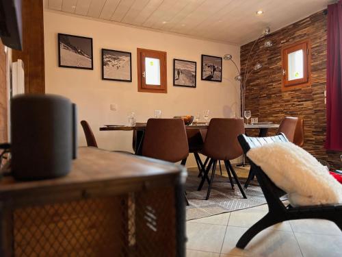 une salle à manger avec une table et des chaises dans l'établissement Chalet des Grangettes avec jardin, sauna et Appli Roadbook - Huez, à Huez