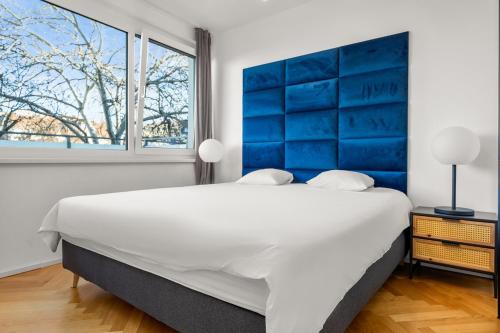 - une chambre avec un grand lit blanc et une tête de lit bleue dans l'établissement Vienna Chic Residences #Suite 14, à Vienne