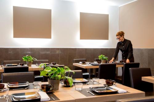 a man standing at a table in a restaurant at Park Hotel Sabina in Magliano Sabina