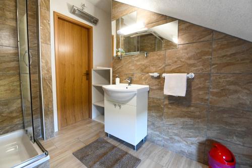 a bathroom with a sink and a shower at Holiday Home Donji Lepuri in Lisičići