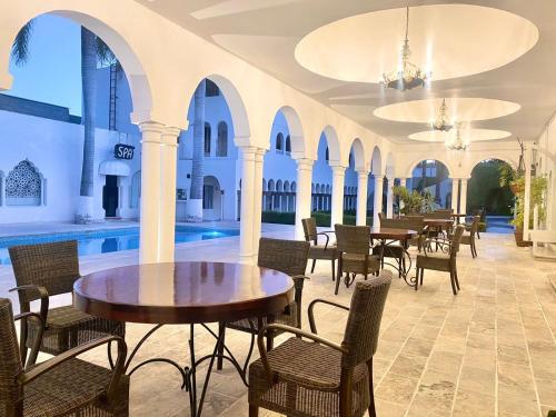a dining room with tables and chairs and a pool at Aldea del Bazar in Tehuacán