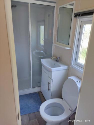 a bathroom with a toilet and a sink and a shower at mini-camping 't Bergje in Serooskerke