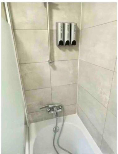 a shower with a water hose in a bathroom at Rosa House in Darlington