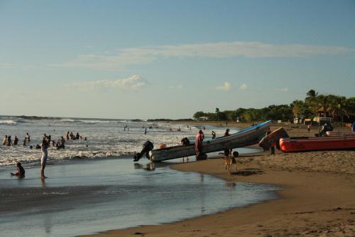 un grupo de personas en una playa con barcos en Camping Ojo de Agua en Nagarote
