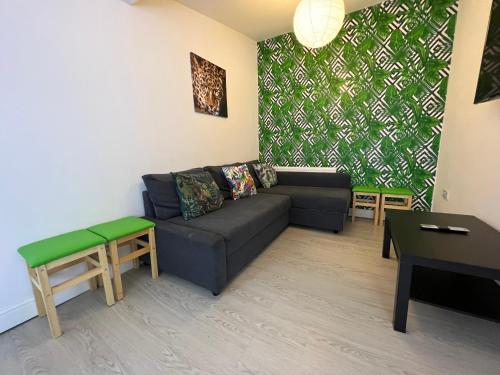 a living room with a couch and a table at Sunnyside Aparthotel Tropical suite, 10 min from Blackpool tower, outside space, free parking in Blackpool