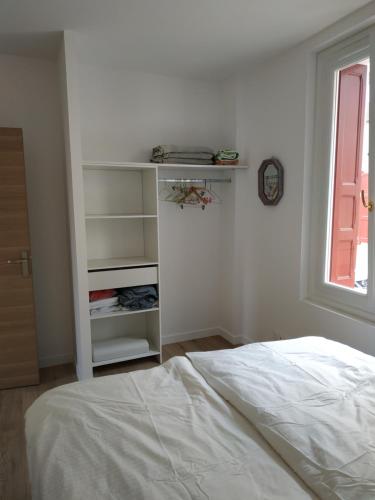 a white bedroom with a bed and a window at Port Heaven, a deux pas du port, grand balcon in Port-Vendres