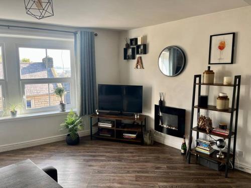 a living room with a flat screen tv and a window at Boutique penthouse apartment with rooftop terrace in Clitheroe