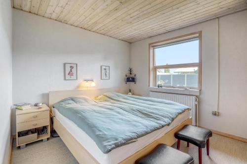 a bedroom with a bed and a window and a chair at Casa Fyrrevænget in Billund