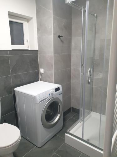a bathroom with a washing machine and a shower at Apartmán Bambuľka in Slovenská ľupča