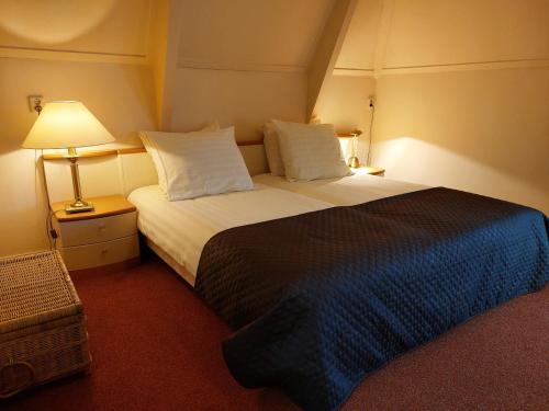 een hotelkamer met een groot bed met 2 kussens bij Boetiek Hotel Marum in Marum