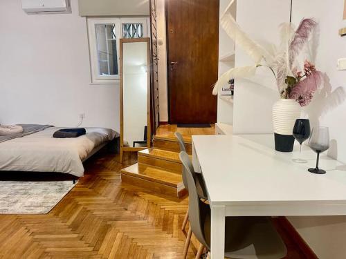 um quarto com uma mesa branca e uma cama e uma mesa e cadeiras em The Love Nest at Central Athens Kolonaki em Atenas