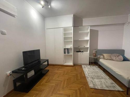 a bedroom with a bed and a desk and a television at The Love Nest at Central Athens Kolonaki in Athens