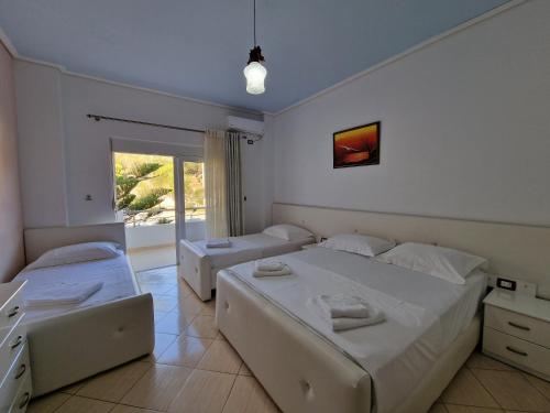 a bedroom with two beds and a window at Hotel Artur in Ksamil
