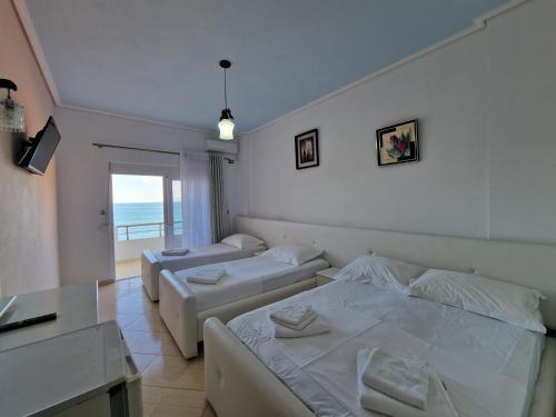 a bedroom with two beds and a balcony at Hotel Artur in Ksamil