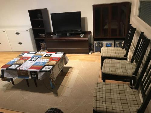 een woonkamer met een salontafel en 2 stoelen bij Spacious 3 room flat with balcony at City Center in Kerava