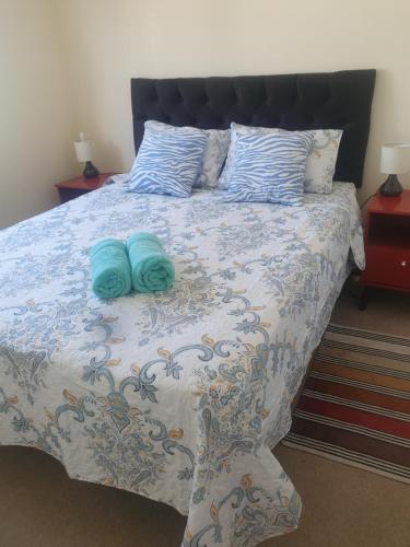 a bedroom with a bed with two blue pillows at Departamento 2D 1B Lircay in Talca