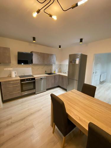 a large kitchen with a wooden table and a wooden floor at Apartman M&M in Žilina