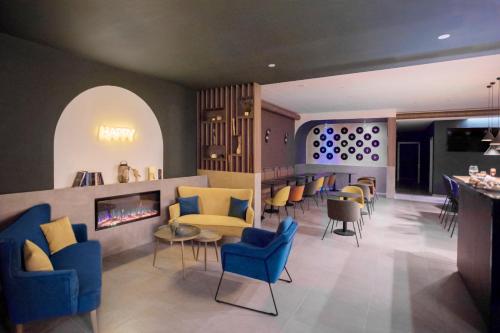 a lobby with blue chairs and a fireplace at Moody smart & comfy Hotel in Terranuova Bracciolini