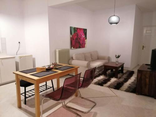 ein Wohnzimmer mit einem Tisch und einem Sofa in der Unterkunft Armonia C1 in Tríkala